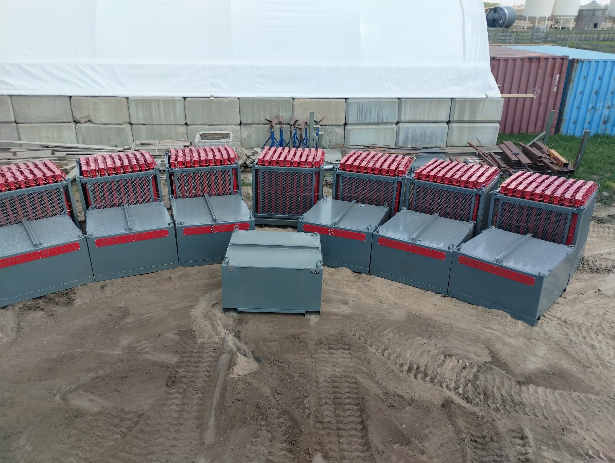Metro Safety Rail staging containers arranged on site, loaded with guardrail components ready for hoisting.